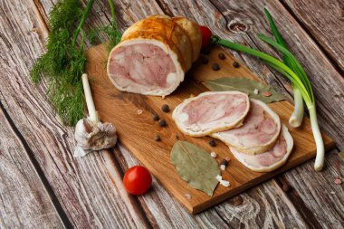 Ahşap arka planda izole edilmiş marul yaprağı desenli ızgara tavuklu rulo. Taze et ve kısmen dilimlenmiş. Tavuklu jambon ve lezzetli tavuk eti.