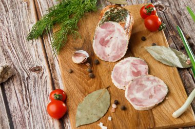 Ahşap arka planda izole edilmiş marul yaprağı desenli ızgara tavuklu rulo. Taze et ve kısmen dilimlenmiş. Tavuklu jambon ve lezzetli tavuk eti.