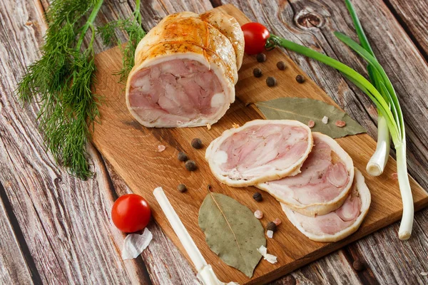 Ahşap arka planda izole edilmiş marul yaprağı desenli ızgara tavuklu rulo. Taze et ve kısmen dilimlenmiş. Tavuklu jambon ve lezzetli tavuk eti.