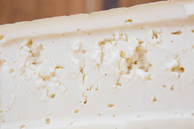 Bir dilim sert peynir, keçi sütü. Tipik yumuşak doku ve beyaz renk.