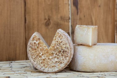 Çiftlik mutfağının ahşap arka planında iki büyük organik peynir kafalar. Yiyecek konsepti