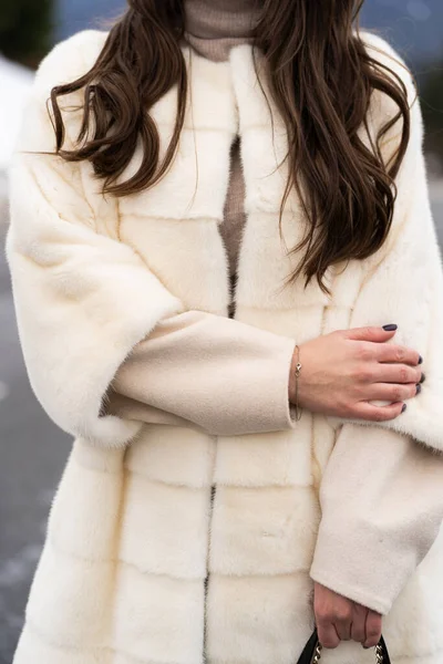 Close up chica posando en la carretera en el fondo de los bosques de invierno. Mujer glamurosa con suéter elegante, abrigo de piel blanco de moda. Concepto de piel y moda. Gente hermosa . — Foto de Stock