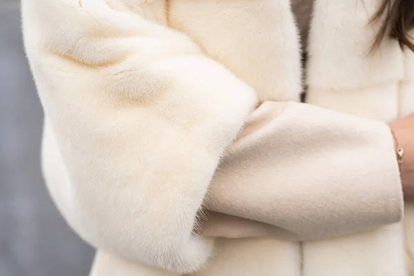 Κοντινό πλάνο κορίτσι ποζάρουν στο δρόμο για το χειμώνα δάσος φόντο. Λαμπερή γυναίκα που φοράει κομψό πουλόβερ, λευκό γούνινο παλτό της μόδας. Γούνα και μόδα έννοια. Όμορφοι άνθρωποι. — Φωτογραφία Αρχείου
