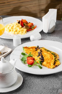 Peynirli omlet, vişneli domates ve beyaz mermer arka planda izole edilmiş ekşi ekmek. Ev yapımı yemek. Lezzetli bir kahvaltı. Seçici odaklanma. Dikey fotoğraf.