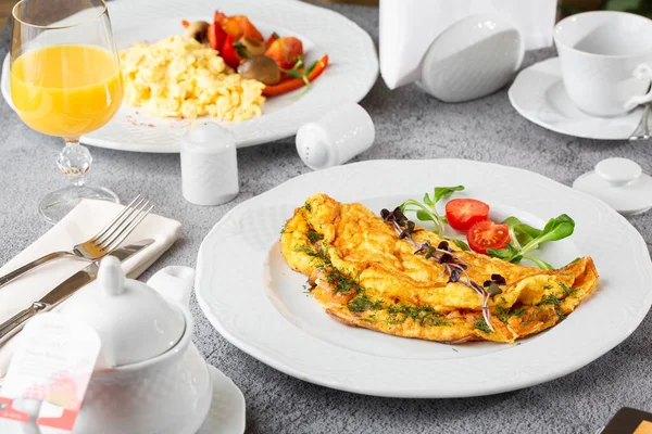 Peynirli omlet, vişneli domates ve beyaz mermer arka planda izole edilmiş ekşi ekmek. Ev yapımı yemek. Lezzetli bir kahvaltı. Seçici odaklanma. Hotizontal fotoğraf.