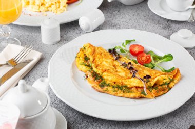 Peynirli omlet, vişneli domates ve beyaz mermer arka planda izole edilmiş ekşi ekmek. Ev yapımı yemek. Lezzetli bir kahvaltı. Seçici odaklanma. Hotizontal fotoğraf.