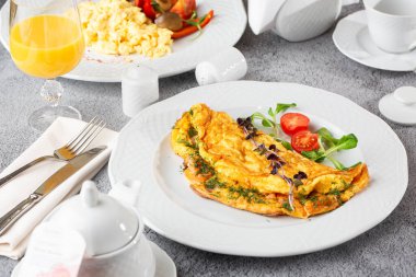Peynirli omlet, vişneli domates ve beyaz mermer arka planda izole edilmiş ekşi ekmek. Ev yapımı yemek. Lezzetli bir kahvaltı. Seçici odaklanma. Hotizontal fotoğraf.