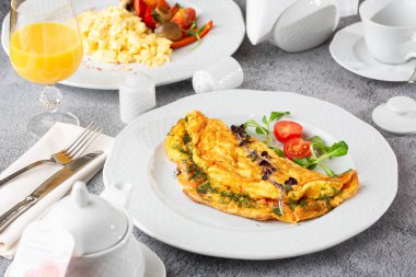 Peynirli omlet, vişneli domates ve beyaz mermer arka planda izole edilmiş ekşi ekmek. Ev yapımı yemek. Lezzetli bir kahvaltı. Seçici odaklanma. Hotizontal fotoğraf.