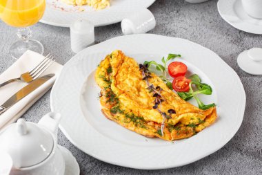 Peynirli omlet, vişneli domates ve beyaz mermer arka planda izole edilmiş ekşi ekmek. Ev yapımı yemek. Lezzetli bir kahvaltı. Seçici odaklanma. Hotizontal fotoğraf.