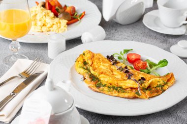 Peynirli omlet, vişneli domates ve beyaz mermer arka planda izole edilmiş ekşi ekmek. Ev yapımı yemek. Lezzetli bir kahvaltı. Seçici odaklanma. Hotizontal fotoğraf.