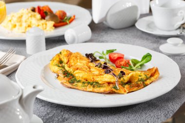 Peynirli omlet, vişneli domates ve beyaz mermer arka planda izole edilmiş ekşi ekmek. Ev yapımı yemek. Lezzetli bir kahvaltı. Seçici odaklanma. Hotizontal fotoğraf.