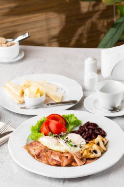 Haşlanmış yumurta, sebze, jambon, domates, kırmızı fasulye ve beyaz mermer arka planda izole edilmiş ekşi ekmek. Ev yapımı yemek. Lezzetli bir kahvaltı. Seçici odak.