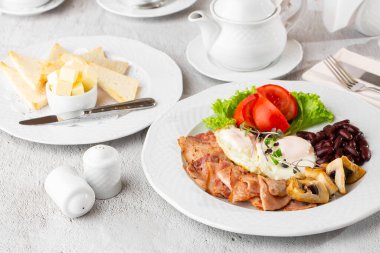 Haşlanmış yumurta, sebze, jambon, domates, kırmızı fasulye ve beyaz mermer arka planda izole edilmiş ekşi ekmek. Ev yapımı yemek. Lezzetli bir kahvaltı. Seçici odak.