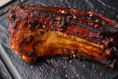 Izgara ve barbekü sıcak domuz kaburga sıcak biber ve siyah taş arka plan üzerinde sıcak sos ile. Izole. Erkekler için yemek. Baharatlı