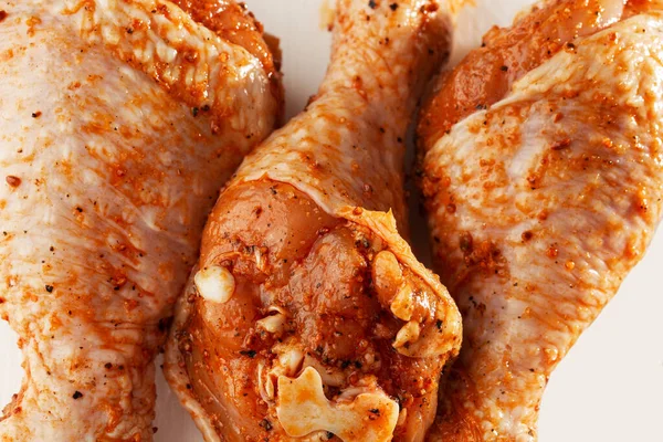 Raw drumsticks on white background. Chicken legs. Raw chicken marinated legs. Top view. Food Background. Cooking content. Uncooked meat. Meat shop concept.