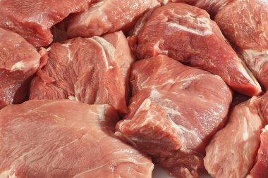 Beyaz arka planda domuz filetosu dilimler. Çiğ domuz eti. Et dükkanı ve çiftlik reklamı. Çeşitli et çeşitleri ve pişirmeye hazır konsept. Üst Manzara. Metin için boşluk