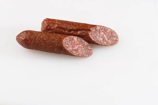 Industrielle Herstellung von Wurst. Geräucherte Wurst auf einem rustikalen Holztisch mit frischen Kräutern und Gewürzen, Naturprodukt aus biologischem Anbau, hergestellt nach traditionellen Methoden. — Stockfoto