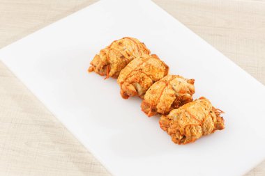 Ahşap arka planda izole edilmiş marul yaprağı desenli ızgara tavuklu rulo. Taze et ve kısmen dilimlenmiş. Tavuklu jambon ve lezzetli tavuk eti. Organik çiftlikten doğal ürün..