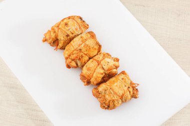 Ahşap arka planda izole edilmiş marul yaprağı desenli ızgara tavuklu rulo. Taze et ve kısmen dilimlenmiş. Tavuklu jambon ve lezzetli tavuk eti. Organik çiftlikten doğal ürün..