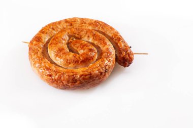 Beyaz arka planda geleneksel spiral şeklinde salyangoz sosisi. Izgara yuvarlak sosis. Lezzetli barbekü. Doğal kabuklu lezzetli bir geleneksel köy sosisi var, salyangoza sarılmış..