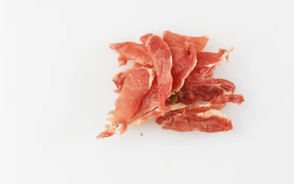 Köttrökt torkat kött - rått köttkorvskött. Närbild på välsmakande skivad kyckling basturma på pergament på en träskiva på en trä bakgrund i en sammansättning med kryddor. Öl mellanmål. Pastirma — Stockfoto