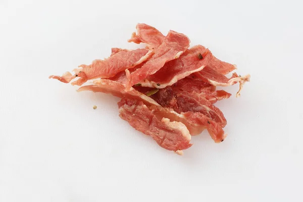 Meat smoked jerky - raw meat sausage meat. Close up view on tasty sliced Chicken basturma on parchment on a wooden board on a wooden background in a composition with spices. Beer snack. Pastirma — Stock Photo, Image