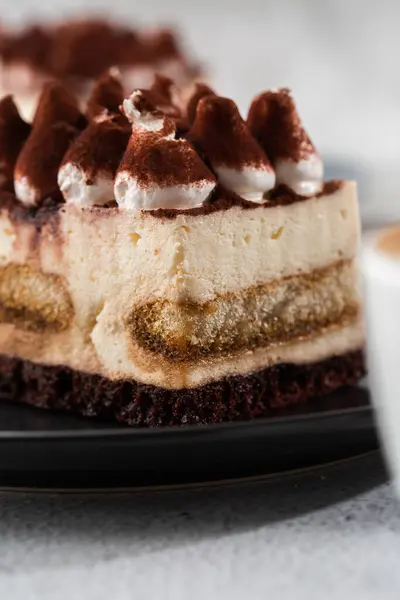 Tiramisu - Sobremesa clássica com mascarpone e café. Delicioso bolo Tiramisu em uma placa de darck em um fundo de mármore leve. Foto vertical . — Fotografia de Stock