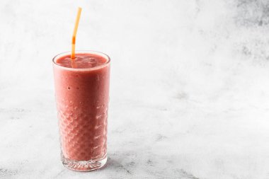 Berry smoothie ya da ahududu pembesi, parlak mermer arka planda kırmızı milkshake. Genel görünüm, kopyalama alanı. Milkshake kafe menüsü reklamı. Kahve dükkanı menüsü. Yatay fotoğraf.