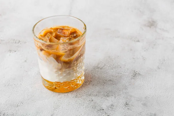 Glas mit kaltem Brühkaffee und Milch isoliert auf hellem Marmorhintergrund. Overhead-Ansicht, Kopierraum. Werbung für die Cafékarte. Kaffeehaus-Speisekarte. Vertikales Foto. — Stockfoto