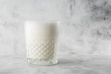 Parlak mermer arka planda izole edilmiş bir bardak soğuk süt. Genel görünüm, kopyalama alanı. Kafe menüsü reklamı. Kahve dükkanı menüsü. Yatay fotoğraf.