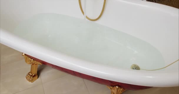 Grifo con agua corriente en fregadero blanco. Un chorro de agua del grifo llena la bañera. Vierte la bañera. Llena el baño con agua. Agua del grifo al baño. Magia negra 4k — Vídeos de Stock