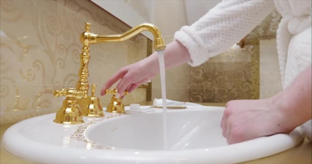 Молодые люди и уход за телом. Человек полоскания руки в современной ванной комнате дизайна дома. Женщина моет женскую руку с мылом и водой под краном в гостиничном номере во время поездки. черная магия 4k — стоковое видео