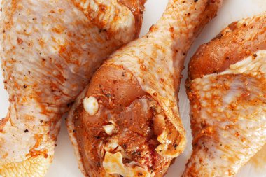 Beyaz arka planda çiğ but. Tavuk bacağı. Çiğ tavuk marine edilmiş bacakları. Üst Manzara. Yemek Geçmişi. Yemek içeriği. Pişmemiş et. Et dükkanı konsepti.