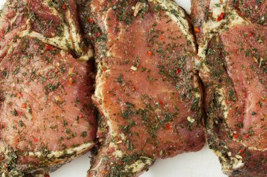 Beyaz arka planda fileto dilimler. Çiğ domuz salamuraya yatırıldı. Et dükkanı ve çiftlik reklamı. Çeşitli et çeşitleri ve pişirmeye hazır konsept. Üst Manzara. Metin için boşluk