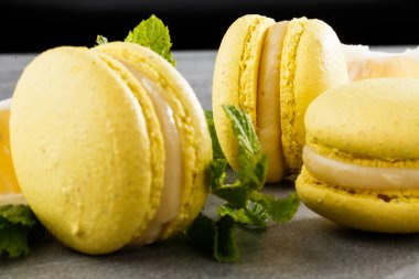 Fransız kurabiyeleri izole edilmiş. Seçici odaklanma. Limonlu ve nane arkaplanlı güzel sarı badem kurabiyeleri. Güzel bir düzenleme. Düz yerde, üst tarafta. Makro fotoğraf.