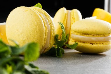 Fransız kurabiyeleri izole edilmiş. Seçici odaklanma. Limonlu ve nane arkaplanlı güzel sarı badem kurabiyeleri. Güzel bir düzenleme. Düz yerde, üst tarafta. Makro fotoğraf.