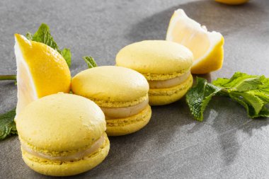 Fransız kurabiyeleri izole edilmiş. Seçici odaklanma. Limonlu ve nane arkaplanlı güzel sarı badem kurabiyeleri. Güzel bir düzenleme. Düz yerde, üst tarafta. Makro fotoğraf.