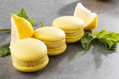 Fransız kurabiyeleri izole edilmiş. Seçici odaklanma. Limonlu ve nane arkaplanlı güzel sarı badem kurabiyeleri. Güzel bir düzenleme. Düz yerde, üst tarafta. Makro fotoğraf.
