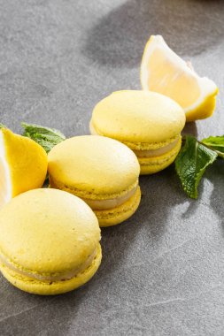 Fransız kurabiyeleri izole edilmiş. Seçici odaklanma. Limonlu ve nane arkaplanlı güzel sarı badem kurabiyeleri. Güzel bir düzenleme. Düz yerde, üst tarafta. Makro fotoğraf.