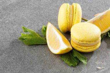 Fransız kurabiyeleri izole edilmiş. Seçici odaklanma. Limonlu ve nane arkaplanlı güzel sarı badem kurabiyeleri. Güzel bir düzenleme. Düz yerde, üst tarafta. Makro fotoğraf.