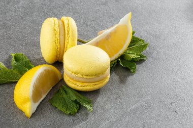 Fransız kurabiyeleri izole edilmiş. Seçici odaklanma. Limonlu ve nane arkaplanlı güzel sarı badem kurabiyeleri. Güzel bir düzenleme. Düz yerde, üst tarafta. Makro fotoğraf.