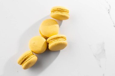 Fransız kurabiyeleri izole edilmiş. Seçici odaklanma. Mermer zemin üzerinde güzel sarı badem kurabiyeleri. Güzel bir düzenleme. Düz yerde, üst tarafta. Makro fotoğraf. Kopyalama alanı ile.