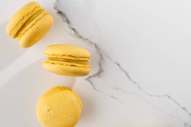 Fransız kurabiyeleri izole edilmiş. Seçici odaklanma. Mermer zemin üzerinde güzel sarı badem kurabiyeleri. Güzel bir düzenleme. Düz yerde, üst tarafta. Makro fotoğraf. Kopyalama alanı ile.