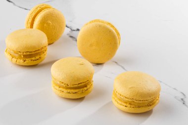 Fransız kurabiyeleri izole edilmiş. Seçici odaklanma. Mermer zemin üzerinde güzel sarı badem kurabiyeleri. Güzel bir düzenleme. Düz yerde, üst tarafta. Makro fotoğraf. Kopyalama alanı ile.