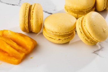 Fransız kurabiyeleri izole edilmiş. Seçici odaklanma. Mermer zemin üzerinde dilimlenmiş mangolu güzel sarı badem kurabiyeleri. Güzel bir düzenleme. Düz yerde, üst tarafta. Makro fotoğraf. Kopyalama alanı ile.