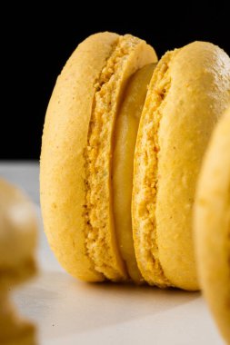 Fransız kurabiyeleri izole edilmiş. Seçici odaklanma. Mermer ve koyu arkaplanda güzel sarı badem kurabiyeleri. Güzel bir düzenleme. Düz yerde, üst tarafta. Makro fotoğraf.