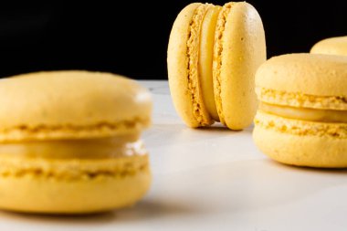 Fransız kurabiyeleri izole edilmiş. Seçici odaklanma. Mermer ve koyu arkaplanda güzel sarı badem kurabiyeleri. Güzel bir düzenleme. Düz yerde, üst tarafta. Makro fotoğraf.