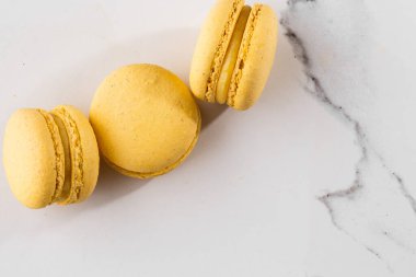 Fransız kurabiyeleri izole edilmiş. Seçici odaklanma. Mermer zemin üzerinde güzel sarı badem kurabiyeleri. Güzel bir düzenleme. Düz yerde, üst tarafta. Makro fotoğraf. Kopyalama alanı ile.