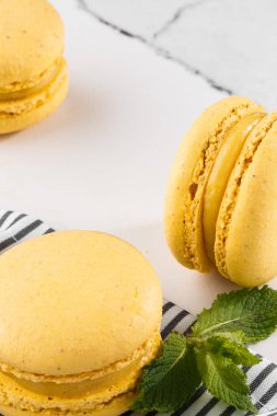 Fransız kurabiyeleri izole edilmiş. Seçici odaklanma. Mermer zemin üzerinde çizgili peçeteli güzel sarı badem kurabiyeleri. Güzel bir düzenleme. Düz yerde, üst tarafta. Makro fotoğraf.