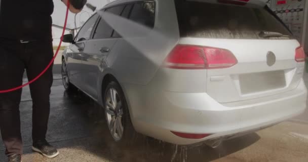 Повільне відео руху процесу миття автомобілів на самообслуговуванні автомийки. струмінь води з високим тиском змиває бруд з автомобіля. Вид збоку. Спінений миючий засіб з автомобіля. 4k — стокове відео